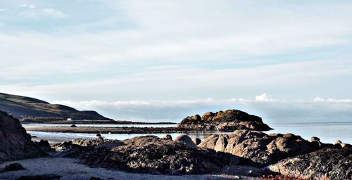 Rocks on beach against sky