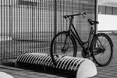 Bicycle parked in rack on sunny day