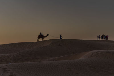 Silhouette people walking at desert