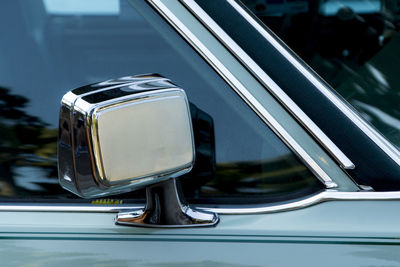 Detail of a cyan colored vintage car rearview mirror. salvador bahia brazil.