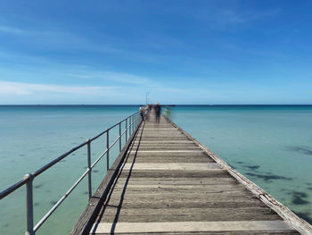 Pier over sea against blue sky