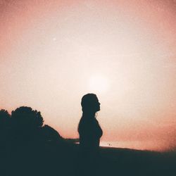 Silhouette woman standing against sky during sunset