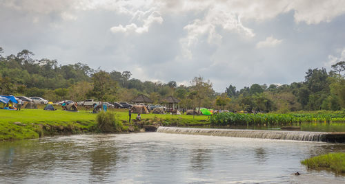 Scenic view of river by trees against sky