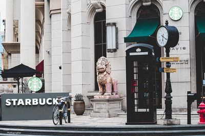 Statue on street against building in city