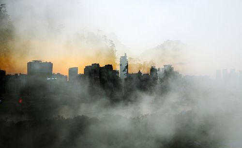 Buildings in city during foggy weather