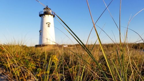 Low angle view of lighthouse on field against clear sky