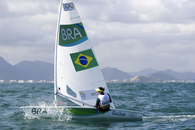 Man in boat on sea against sky