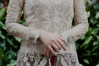 Midsection of bride standing outdoors