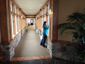 Rear view of woman walking in corridor of building