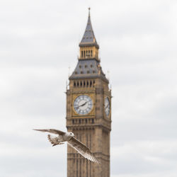Low angle view of clock tower against cloudy sky