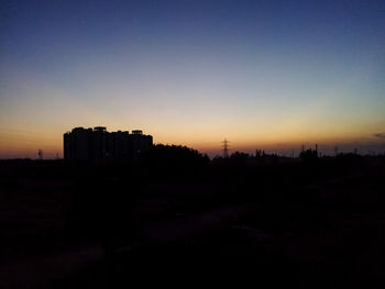 Built structure on landscape at sunset