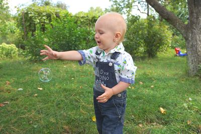 Baby boy playing with bubble at back yard