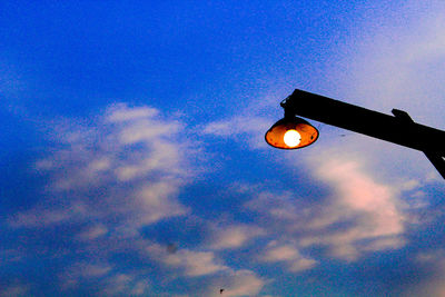 Low angle view of illuminated street light against blue sky