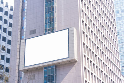 Low angle view of blank billboard on building in city