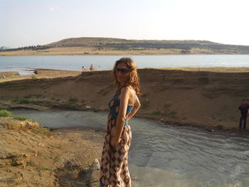 Young woman on beach against clear sky