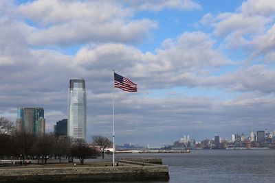 Flag by buildings against sky in city