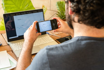 Midsection of businessman photographing laptop