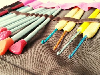 Close-up of multi colored knitting needles on fabric