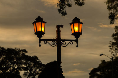 Low angle view of illuminated street light against sky