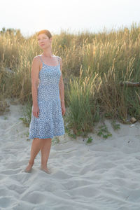 Portrait of young woman standing at beach