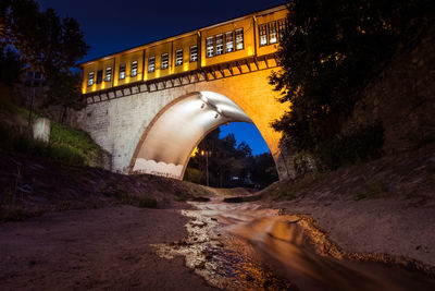 Arch bridge against sky at night