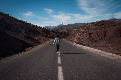 Rear view of man on road against sky