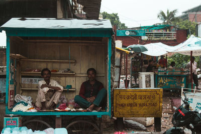 People sitting at market stall