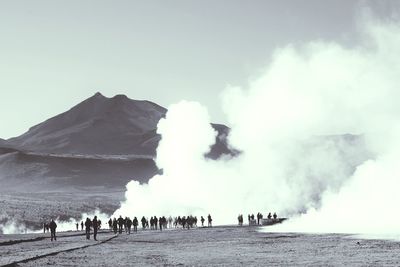 Panoramic view of people on shore against sky