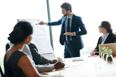 Businessman giving presentation to colleagues in office