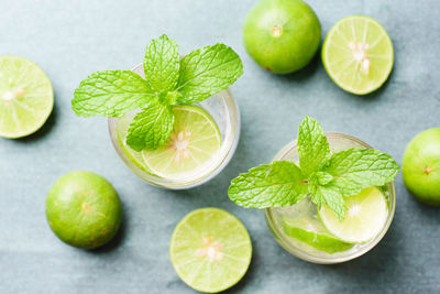 High angle view of drinks with limes on table