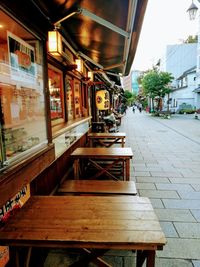 Empty chairs and tables in street by building