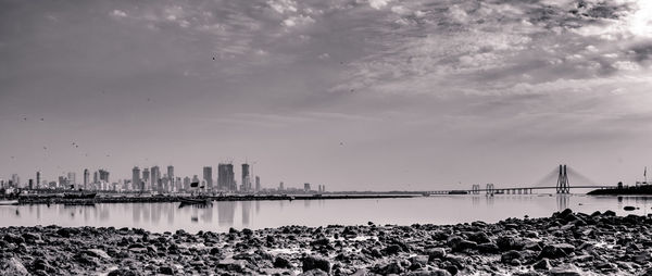 View of city by sea against sky