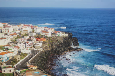 High angle view of sea and buildings against sky