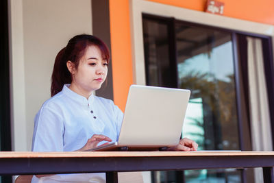 Woman sitting on table at home