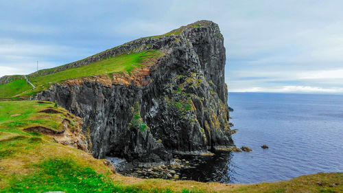 Scenic view of rocks on sea against sky