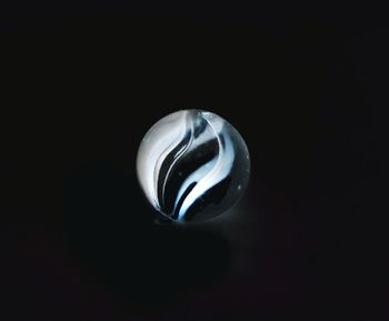 Close-up of crystal ball on table against black background