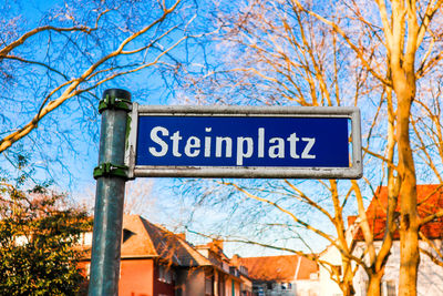 Low angle view of information sign against trees