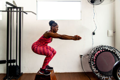 Full length of woman exercising in gym