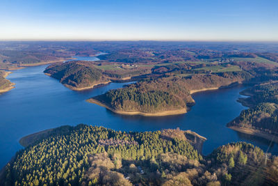 High angle view of lake and mountains against blue sky