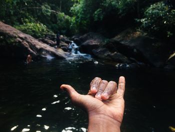 Cropped hand of man in lake