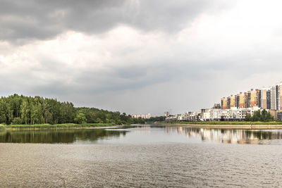 Scenic view of lake by buildings against sky