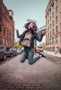 Woman jumping on city street