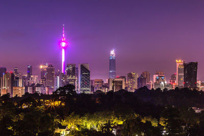 Illuminated buildings against sky at night