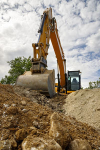 A stopping yellow excavator for rest, at a construction site. vertical view