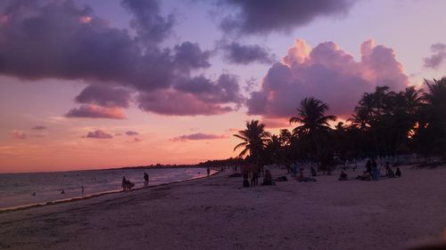 Tourists on beach at sunset