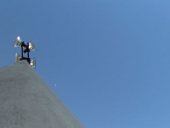 Low angle view of camera against clear blue sky