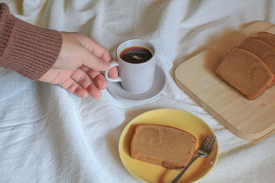 Midsection of woman holding coffee on table