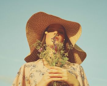 Portrait of woman wearing hat against blue sky