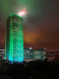 Low angle view of illuminated buildings against sky at night