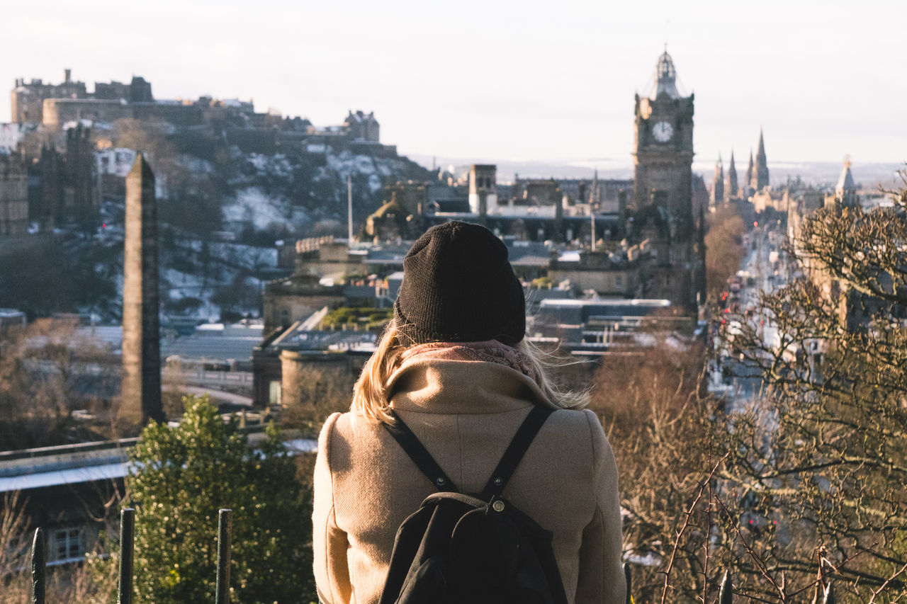 rear view, architecture, built structure, real people, building exterior, leisure activity, outdoors, women, city, lifestyles, one person, standing, day, cityscape, men, sky, nature, mammal